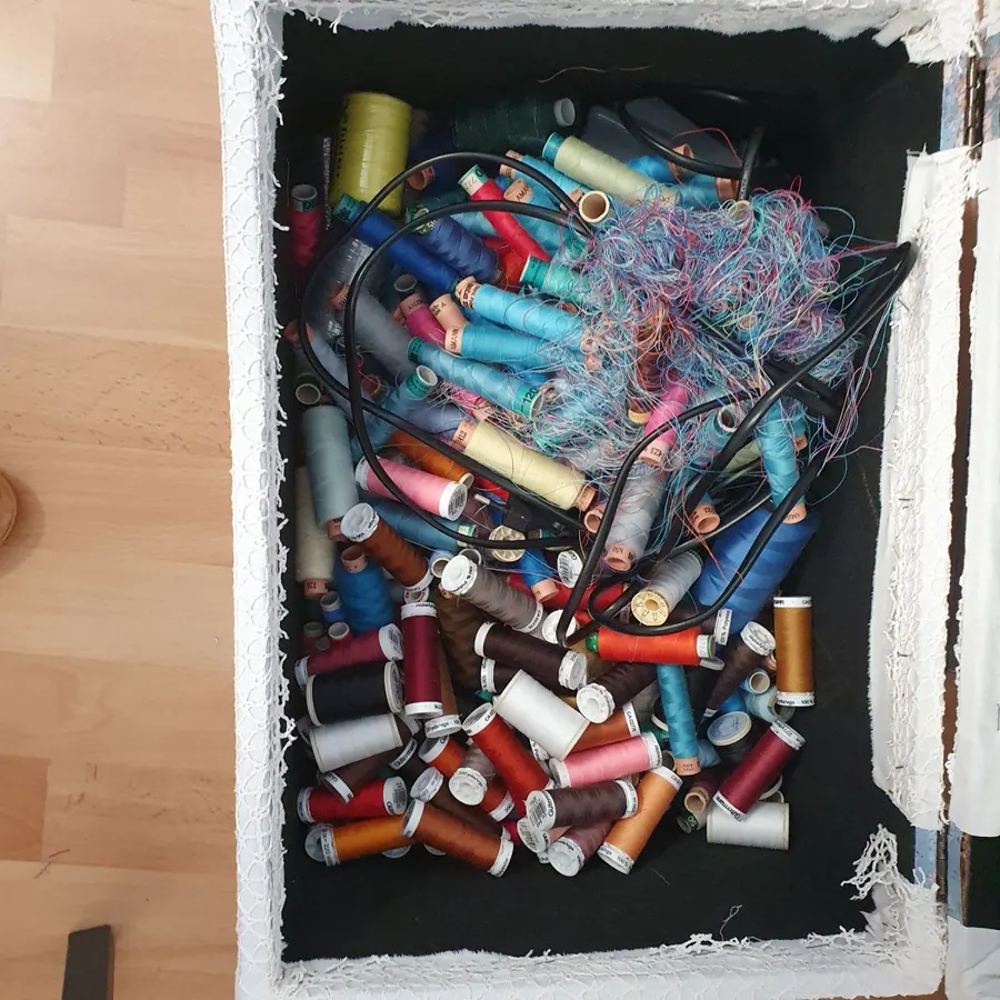 Garn vorher: verknotete Garnrollen in einer Kiste